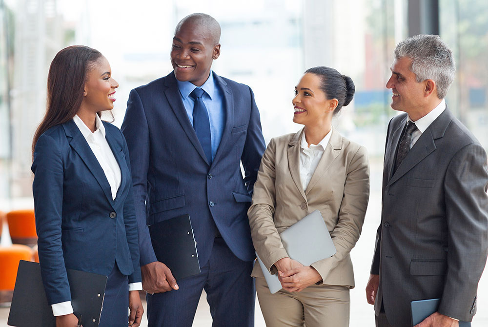 four people of diverse ethnicities in business attire
