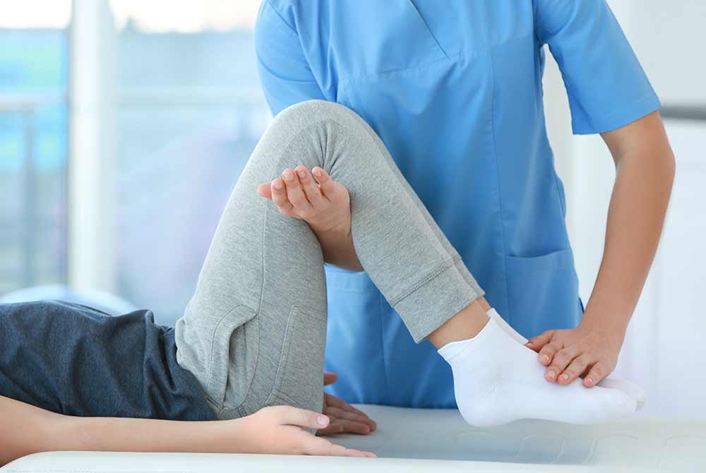 woman receiving physical therapy treatment on knee