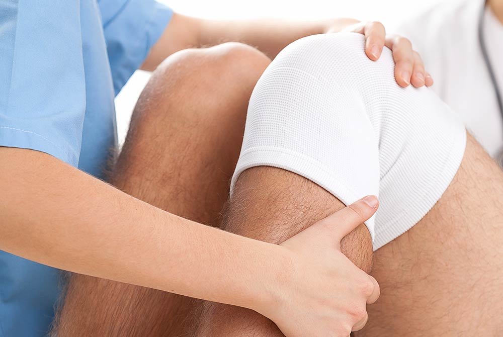 man receiving therapeutic treatment for his knee